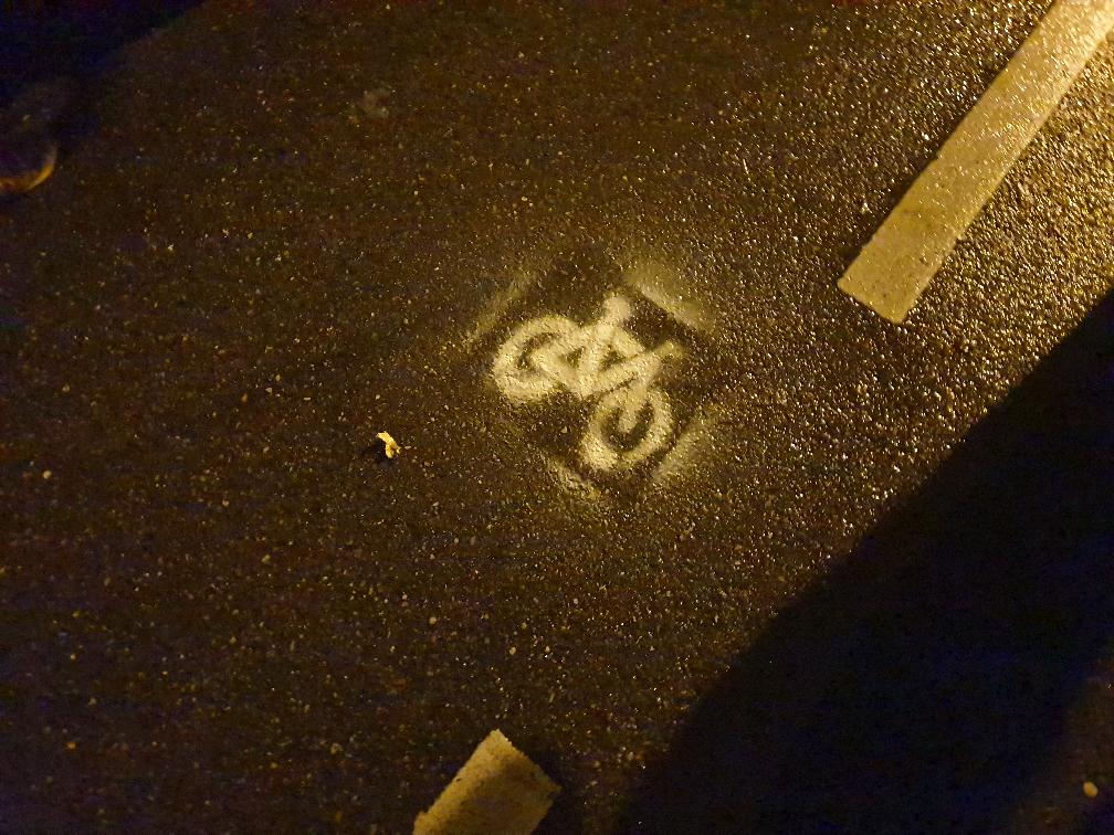Das Bild zeigt ein Stück Straße, auf die mit Sprühkreide ein weißes Fahrrad gezeichnet wurde.