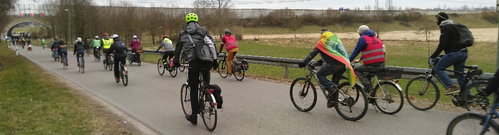 Die Fahrraddemo fährt über eine ländliche Straße auf einen Tunnel unter der A8 zu.
