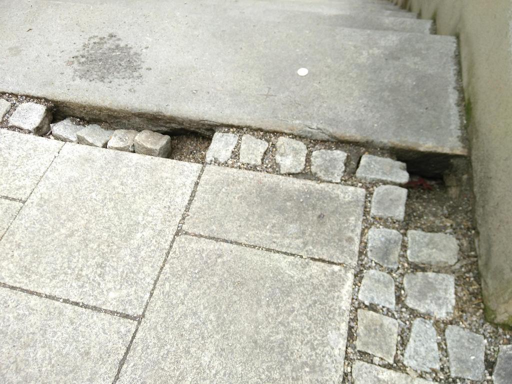 Nahe der obersten Stufe der Treppe vom Fischmarkt zur Straße „Am Hinteren Perlachberg“ tun sich einige Löcher auf. Pflastersteine sind zehn bis zwanzig Zentimeter tief eingesackt.