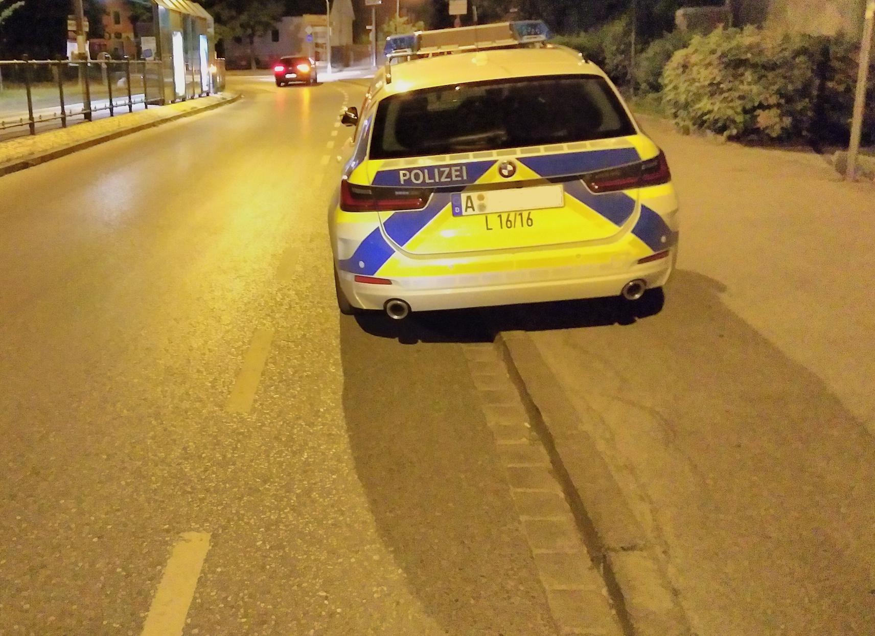 Ein Streifenwagen der Polizei parkt auf einem Radstreifen und Fußweg. Während der Fußweg breit genug ist, dass man vorbei kann, müssen Radfahrer*innen auf die Straße ausweichen.